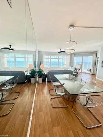 a room with lots of tables a chandelier and living room view