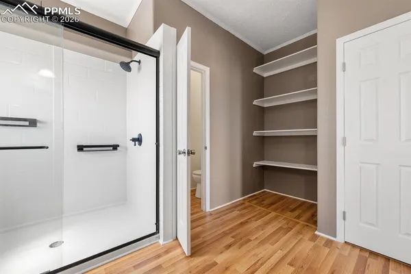 a view of a walk in closet and wooden floor