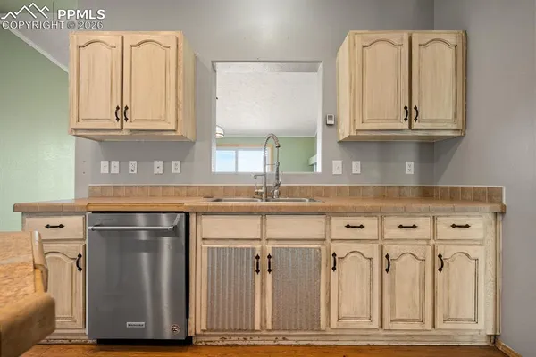 a kitchen with stainless steel appliances granite countertop a sink and cabinets with wooden floor