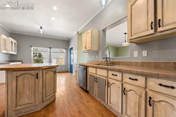 a kitchen with granite countertop a sink cabinets stainless steel appliances and a window