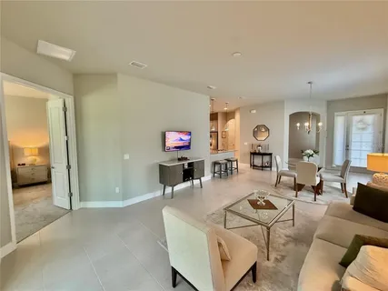 a view of a kitchen from the hallway and a livingroom with furniture