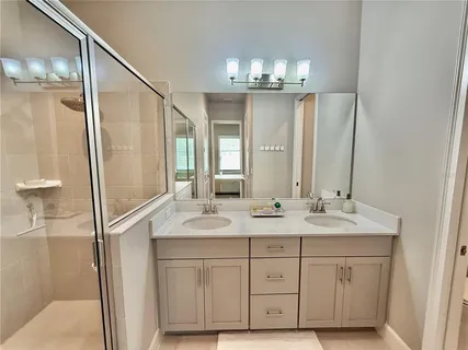 a bathroom with a granite countertop shower sink and mirror