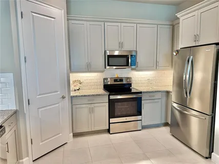 a large kitchen with a sink and cabinets