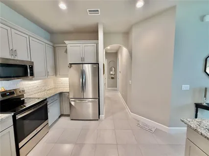 a view of a hallway with wooden floor and a bathroom
