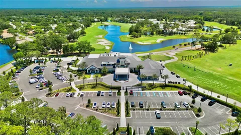 a view of swimming pool with a yard and palm trees