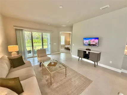 a living room with furniture and a floor to ceiling window