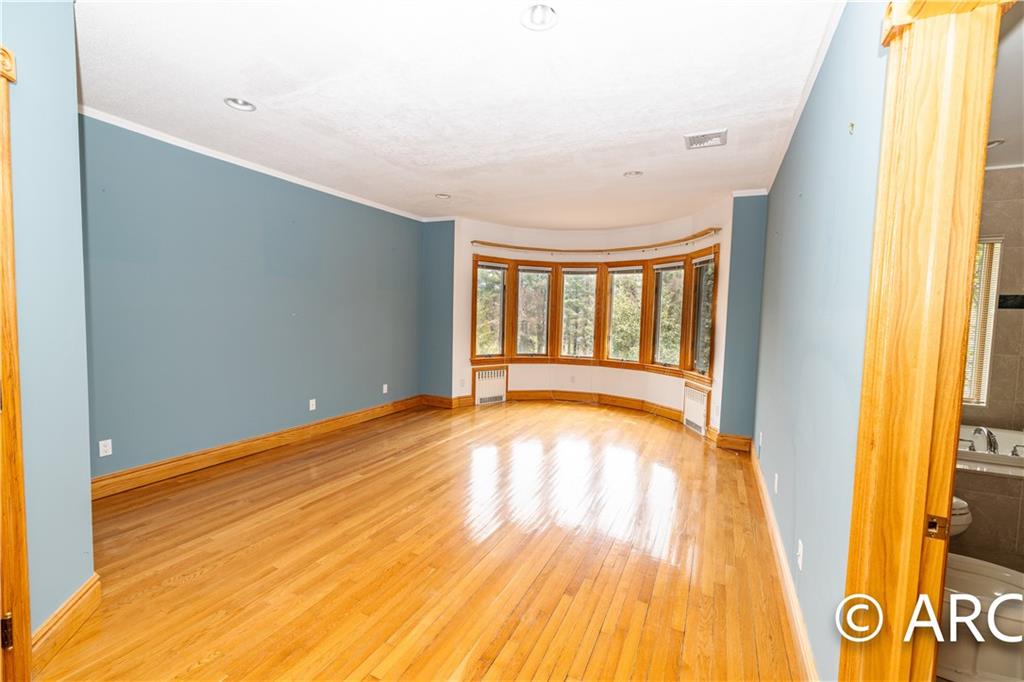 66 Wolver Hollow Road Glen Head, NY 11545 - Photo 24 of 46 a view of an empty room with wooden floor and a window
