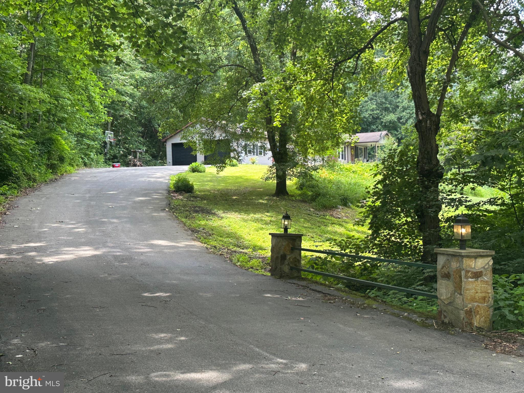 7426 Spring Road Seven Valleys, PA 17360 - Photo 3 of 5 Serene driveway through lush greenery.