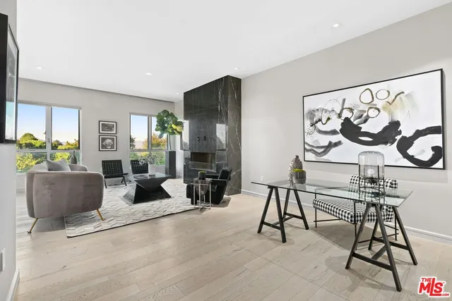 a living room with furniture and a painting on the wall