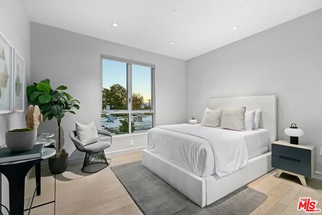 a bedroom with a bed and a potted plant