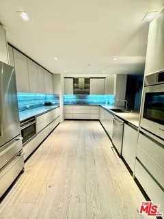 a kitchen with stainless steel appliances granite countertop a sink and wooden cabinets