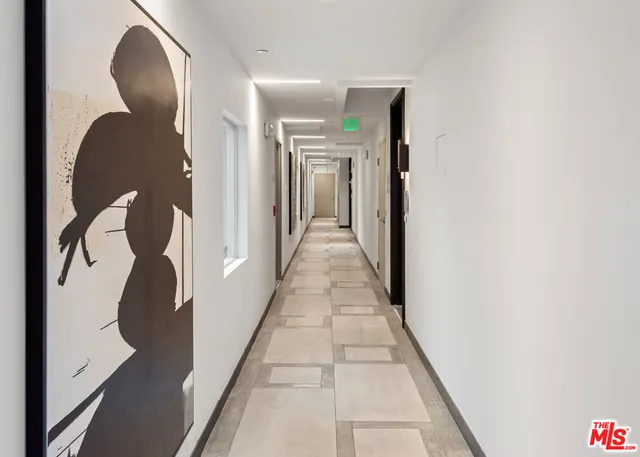 a living room with furniture a large window and white walls