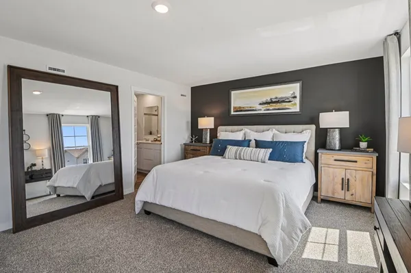 a bedroom with a bed and a large mirror