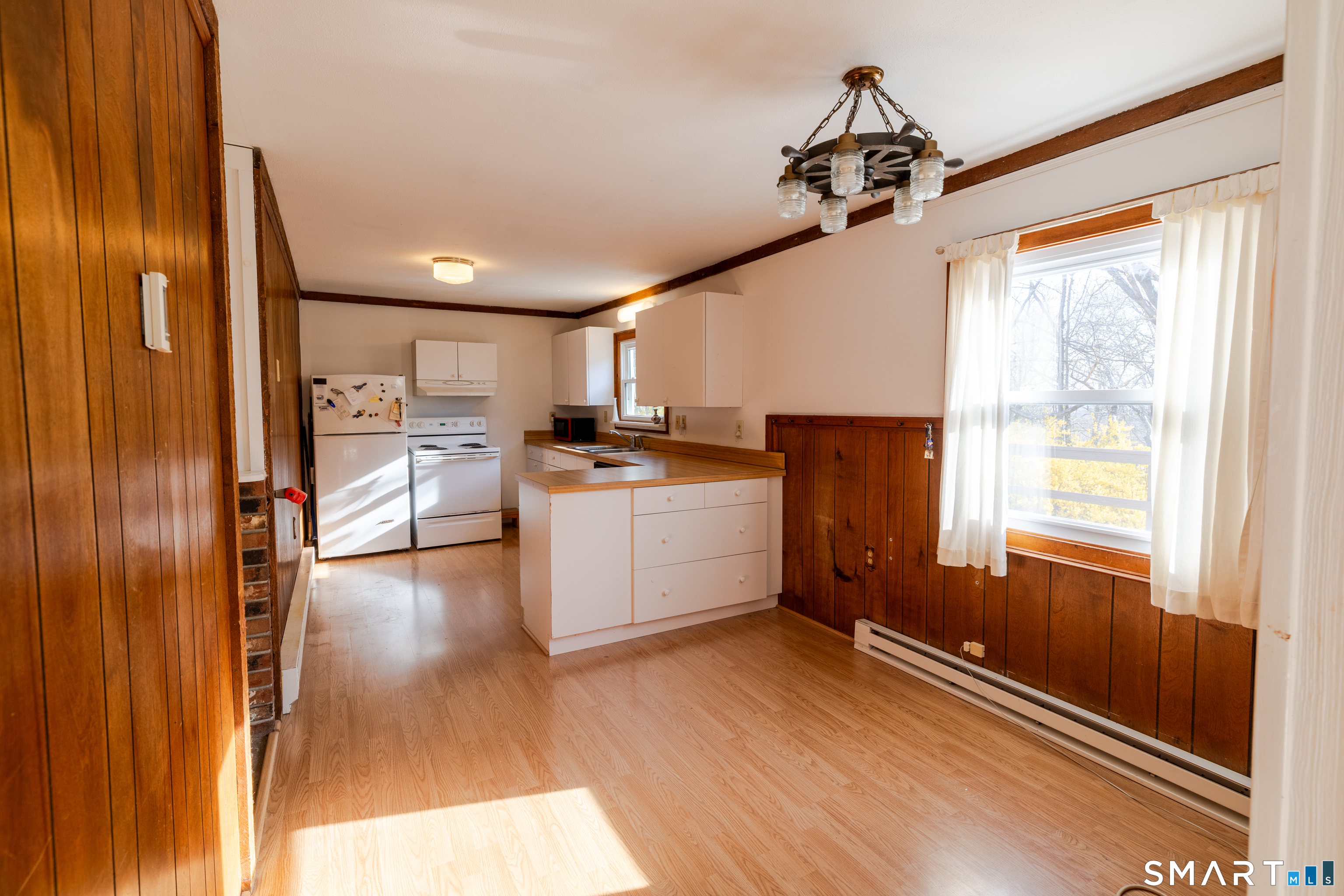 226 Pequot Avenue Groton, CT 06355 - Photo 8 of 11 a kitchen with stainless steel appliances granite countertop a refrigerator a sink dishwasher a stove and a dining table with wooden floor