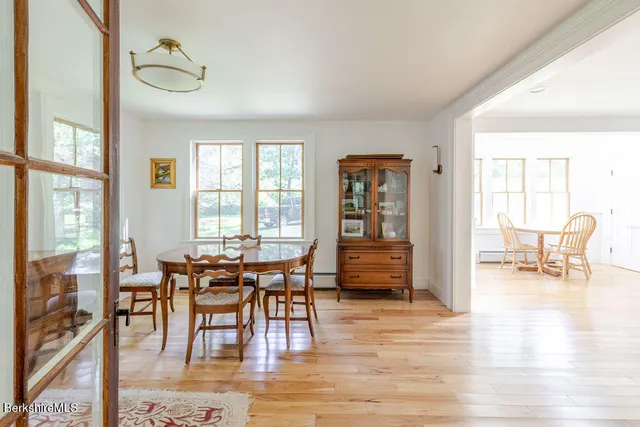 a view of a a dining room with furniture window and wooden floor