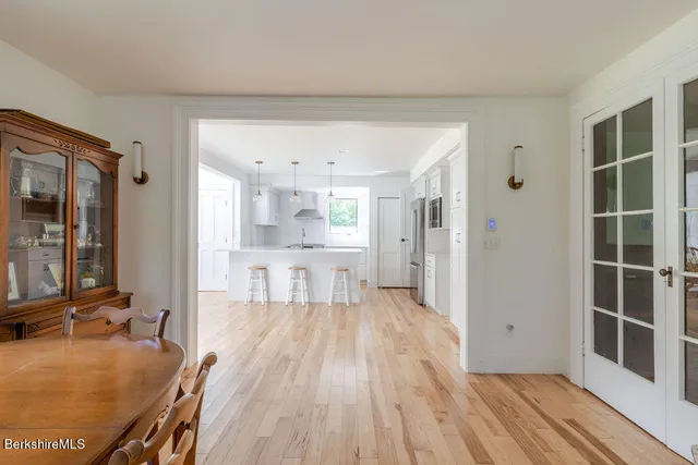 a view of a kitchen with kitchen island wooden floor center island and stainless steel appliances