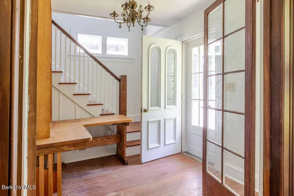 a view of entryway with wooden floor and livingroom view