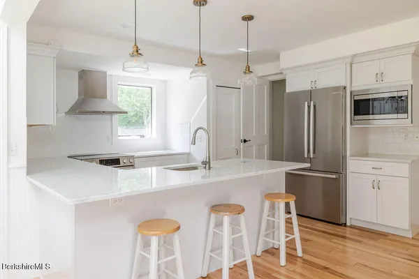 a kitchen with stainless steel appliances granite countertop a sink a stove a refrigerator and island