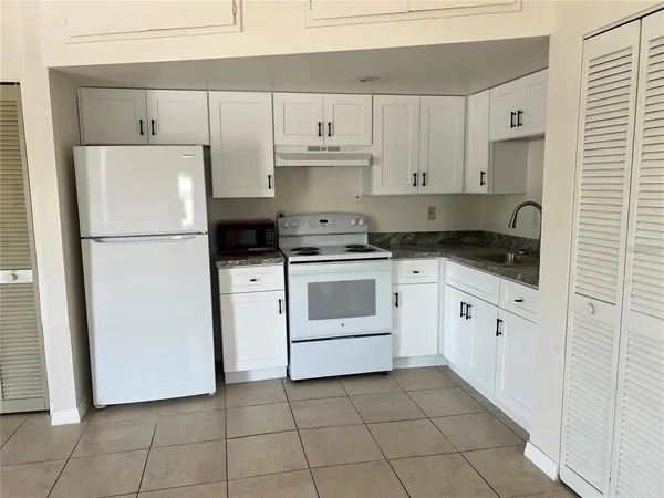 a white refrigerator freezer sitting inside of a kitchen