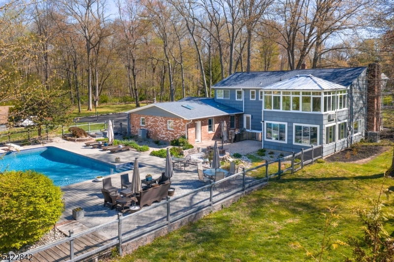 a front view of a house with swimming pool table and chairs