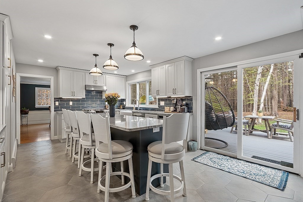 13 Olde Farms Road Boxford, MA 01921 - Photo 16 of 42 a kitchen with stainless steel appliances kitchen island granite countertop a dining table chairs and white cabinets