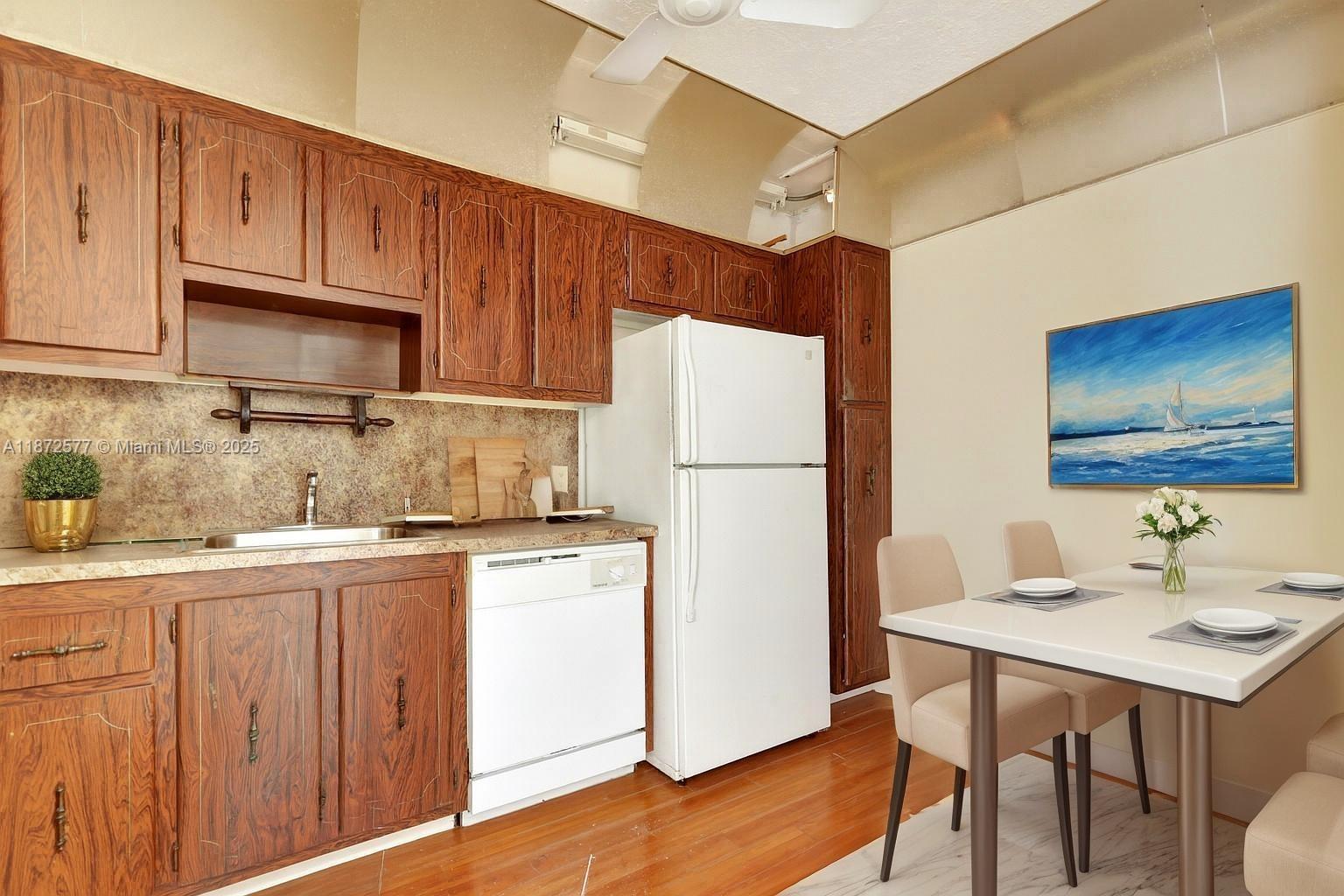 20100 West Country Club Drive, Unit 403 Aventura, FL 33180 - Photo 13 of 24 a kitchen with stainless steel appliances granite countertop a refrigerator a sink dishwasher and white cabinets with wooden floor