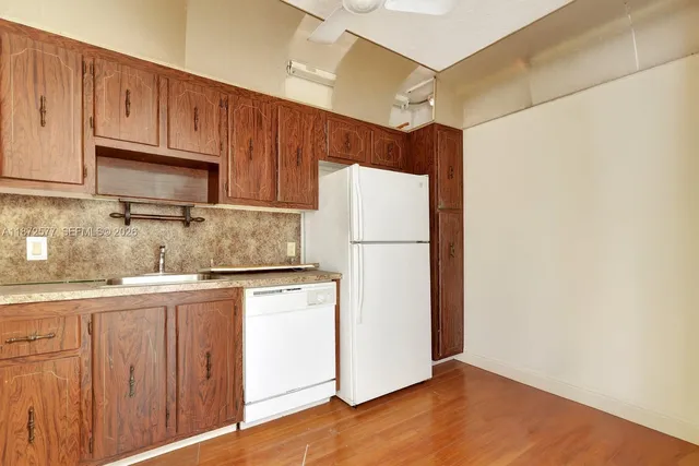 a kitchen with granite countertop wooden cabinets and white appliances