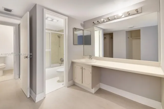 a bathroom with a double vanity sink mirror and bathtub