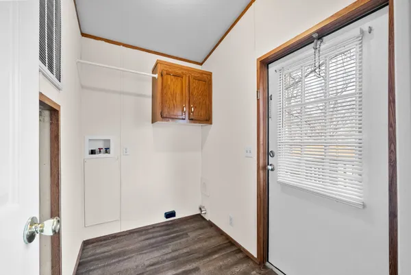 a view of a hallway with wooden floor and a window
