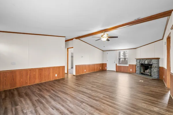 a view of a livingroom with wooden floor and a fireplace