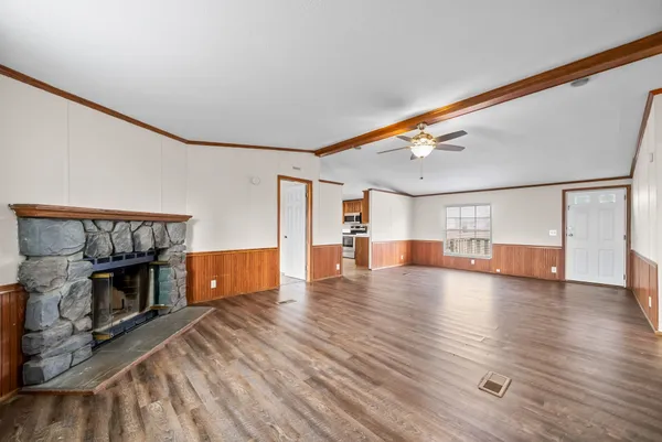 a view of empty room with fireplace and wooden floor