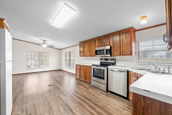 a kitchen with granite countertop wooden floors a stove and a microwave