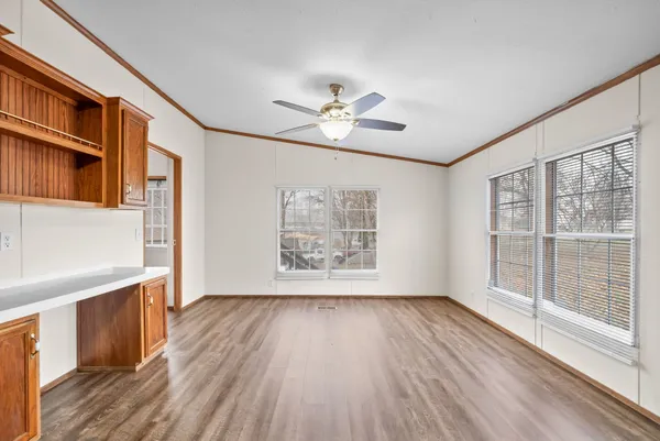 a view of an empty room with a window and wooden floor