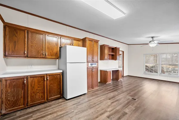 a view of a kitchen with wooden floor and electronic appliances
