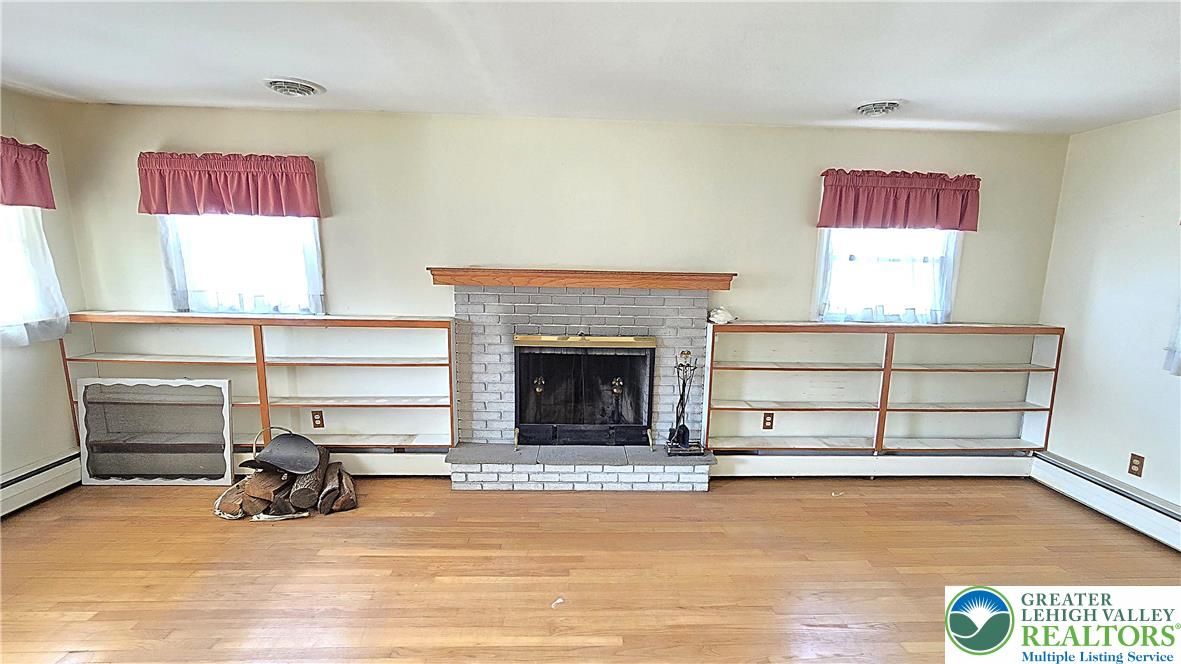232 Virginia Avenue Whitehall, PA 18052 - Photo 4 of 26 a living room with furniture gym equipment and a fireplace