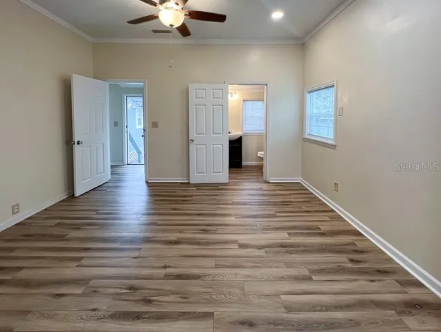 a view of an empty room with window and wooden floor