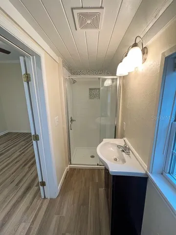 a bathroom with a sink a toilet a mirror and shower