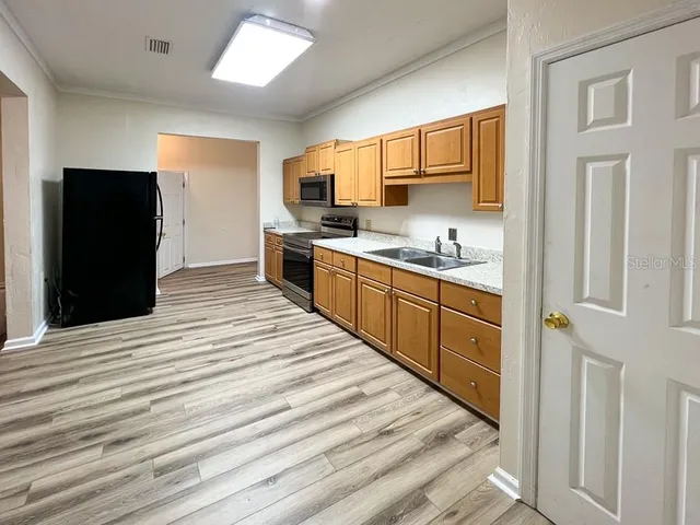 a kitchen with stainless steel appliances granite countertop a refrigerator and a sink