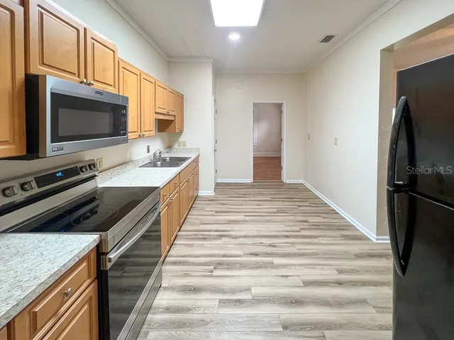 a kitchen with stainless steel appliances a stove microwave and refrigerator