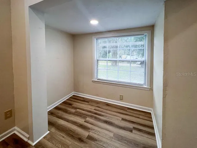 a view of a bedroom with wooden floor and a window