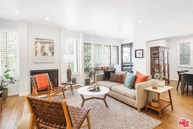 a living room with fireplace furniture and a large window