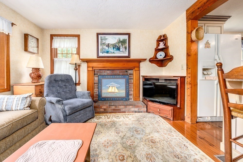 102 Wildwood Road Brewster, MA 02631 - Photo 14 of 41 a living room with furniture and a fireplace