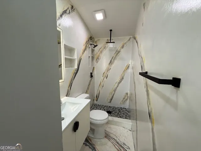 a bathroom with a granite countertop sink toilet and shower