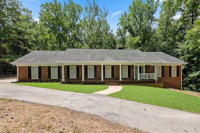 a front view of a house with a yard and trees