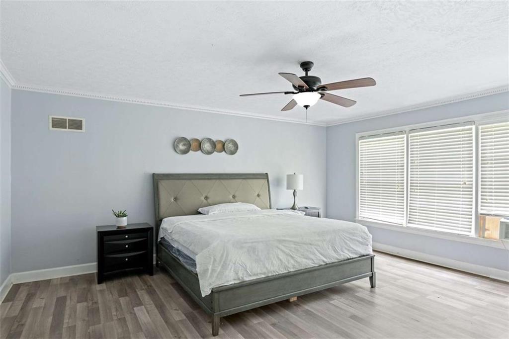 140 Old Fairburn Close Southwest South Fulton, GA 30331 - Photo 24 of 28 a bedroom with a bed and a ceiling fan with a wooden floor