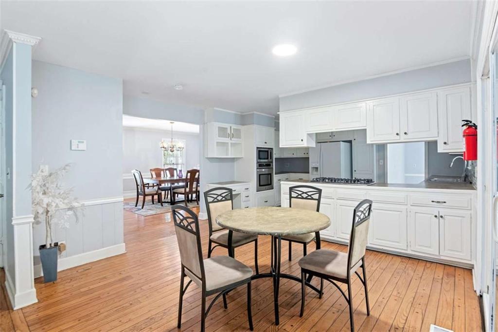 140 Old Fairburn Close Southwest South Fulton, GA 30331 - Photo 7 of 28 a kitchen with stainless steel appliances kitchen island granite countertop a dining table chairs and granite counter tops