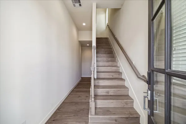 a view of staircase with wooden floor and white walls