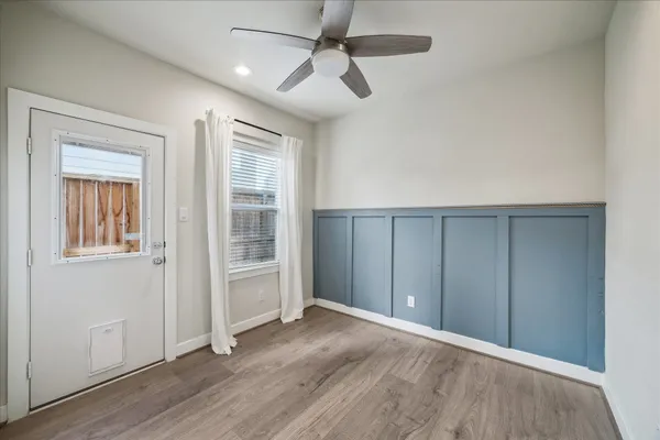an empty room with wooden floor closet and windows