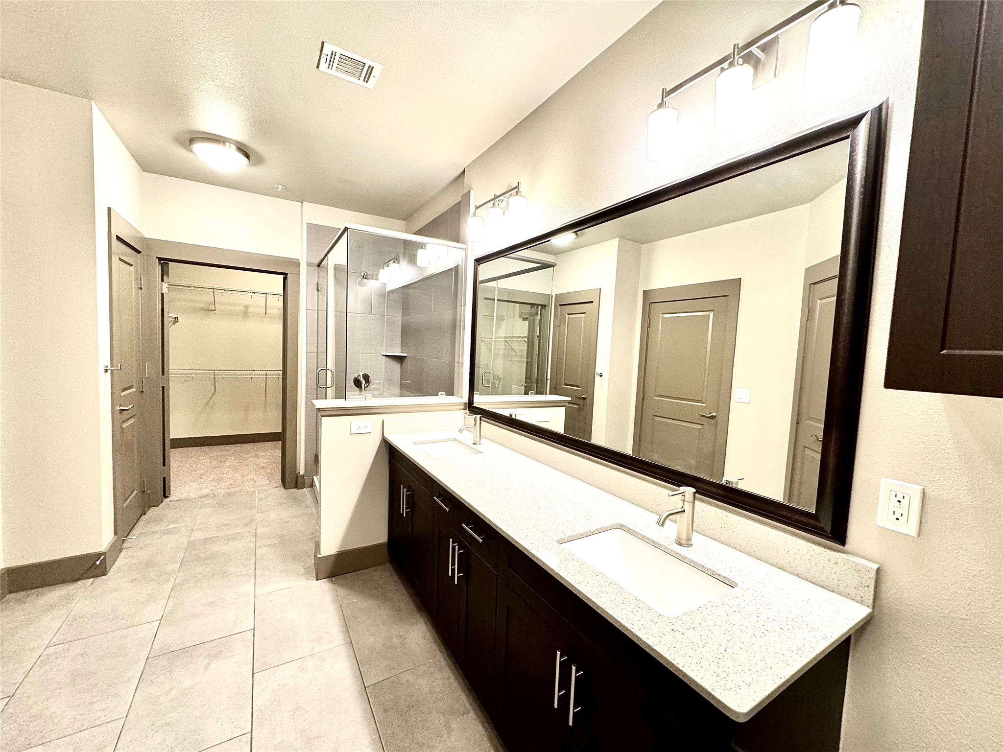 2033 South Gessner Road, Unit 2105 Houston, TX 77063 - Photo 5 of 23 a bathroom with a double vanity sink a mirror and a bathtub