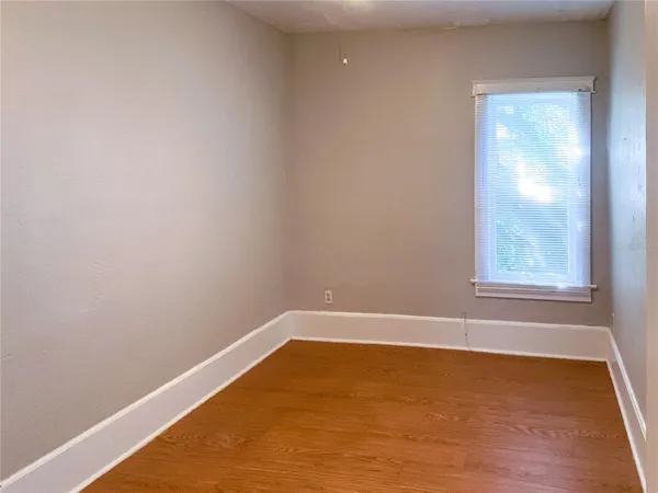 a view of a small space with wooden floor and a window